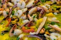 Close up of large portion of mixed seafood cooked with vegetables, available for sale at a street food market, selective focus