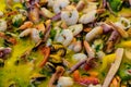 Close up of large portion of mixed seafood cooked with vegetables, available for sale at a street food market, top view or flat la