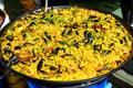 Close up of large portion of traditional Spanish paella dish freshly being cooked with seafood and rice in a frying pan at a stree Royalty Free Stock Photo