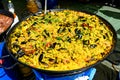 Close up of large portion of traditional Spanish paella dish freshly being cooked with seafood and rice in a frying pan at a stree Royalty Free Stock Photo