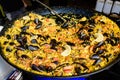 Close up of large portion of traditional Spanish paella dish freshly being cooked with seafood and rice in a frying pan at a stree Royalty Free Stock Photo