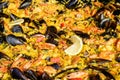 Close up of large portion of traditional Spanish paella dish freshly being cooked with seafood and rice in a frying pan at a Royalty Free Stock Photo