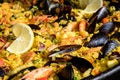 Close up of large portion of traditional Spanish paella dish freshly being cooked with seafood and rice in a frying pan at a Royalty Free Stock Photo