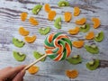 Close-up of a large round fruit candy on a background of slices of kiwi, mandarin Royalty Free Stock Photo