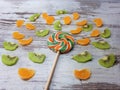 Close-up of a large round fruit candy on a background of slices of kiwi, mandarin Royalty Free Stock Photo