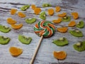 Close-up of a large round fruit candy on a background of slices of kiwi, mandarin Royalty Free Stock Photo