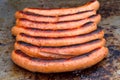 Large sausages frying on an open grill Royalty Free Stock Photo