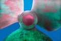 close up, large screw in pink and green colors on a blue background