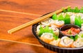 Close up of large set of delicious japanese sushi rolls on a black plastic plate over a wooden table Royalty Free Stock Photo