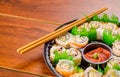 Close up of large set of delicious japanese sushi rolls on a black plastic plate over a wooden table Royalty Free Stock Photo