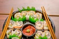 Close up of large set of delicious japanese sushi rolls on a black plastic plate over a wooden table Royalty Free Stock Photo