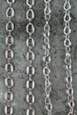 Close up of large shiny metalic silver chains on gray texture background top view Royalty Free Stock Photo