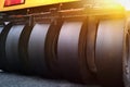 Close-up of large wheels of asphalt paving machines working on the road Royalty Free Stock Photo