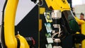 Close-up of large yellow robot machine hand installing some electrical device. Media. Different working robots