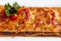 Close-up lasagna on which lie sliced cherry tomatoes and olives Royalty Free Stock Photo