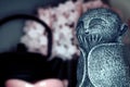 Close up of laughing, giggling, Jizo statue with blurred sakura and tea kettle background