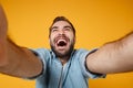 Close up of laughing young man in casual blue shirt posing isolated on yellow orange wall background, studio portrait Royalty Free Stock Photo