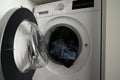 Close-up of a Siemens brand washing machine with the door open with dirty laundry