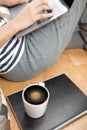 Close up and lay flat view of asian woman working at home with laptop typing hands on wooden floor shows concept of working from Royalty Free Stock Photo