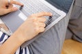 Close up and lay flat view of asian woman working at home with laptop typing hands on wooden floor shows concept of working from Royalty Free Stock Photo