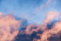 Close up of a layer of clouds colored in sunset colors moving across a bright blue sky Royalty Free Stock Photo