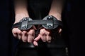 Close-up leather blindfolds in female hands. Unrecognizable woman holds bdsm equipment in the dark. Sexual role-playing