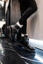 Close-up of leather fashionable autumn-winter warm black-white boots on female legs. New seasonal collection of women`s shoes Royalty Free Stock Photo