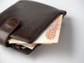 A close-up of a leather wallet full of 5000 rubles banknotes lies on a white background. Side view Royalty Free Stock Photo