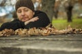 Close up leaves in a table and pensive man sitting on a bench in