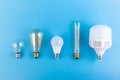 close up led lamps and edison lamps lie flat on an isolated blue background. Energy efficiency concept. Royalty Free Stock Photo