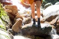 Close up leg hiker asian woman walk a way in the water fall, background forest.