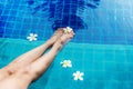 Close up leg lifestyle woman in swimsuit relaxing and spa so happy with cocktail on chaise-longue near swimming pool, summer day. Royalty Free Stock Photo