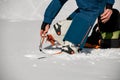 Close-up of leg of man wearing climbing crampons over mountaineering shoes for walking through glacier.