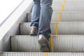 Close up leg of Men wear jeans, leather shoes. Standing on the escalator Royalty Free Stock Photo