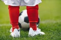 Close up on legs of children soccer player. Young boy kid practice football on grass field Royalty Free Stock Photo