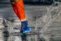 close-up legs male runner in compression socks running puddle on road Royalty Free Stock Photo