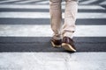 Close up legs of man walking cross street in city Royalty Free Stock Photo