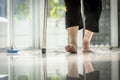 Close up,Legs of old elderly people with cane stick to support her walk,feet are stepping over an electrical socket,risk of