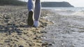 Close-up of the legs of a runner running along the beach and dodging the waves