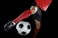 Close up legs and soccer shoe of football player in action kicking ball isolated on black background Royalty Free Stock Photo