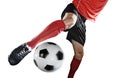 Close up legs and soccer shoe of football player in action kicking ball isolated on white background