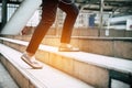 Close up legs of traveling people walking on stepping up stair in modern city. Sneakers and jeans elements. Business and travel Royalty Free Stock Photo