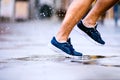 Close up of legs of unrecognizable runner, town, puddle