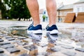 Close up of legs of unrecognizable runner, town, puddle