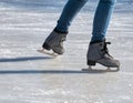 Close up with the legs of a woman with skates on ice. Ice skating recreational activity