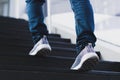 Close up legs of young businessman while walking up the stairs in the modern city with the sunspot background. Go up, success, Royalty Free Stock Photo