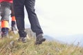 Close-up of legs of young hikers walking on the country path. Young couple trail waking. Focus on hiking shoes