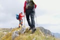 Close-up of legs of young hikers walking on the country path. Young couple trail waking. Focus on hiking shoes