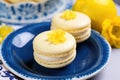 close-up of a lemon macaron on a blue ceramic plate