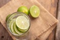 Close up lemon sliced in the glass with soda water and a half of the green lime place on woven sack and wooden table Royalty Free Stock Photo